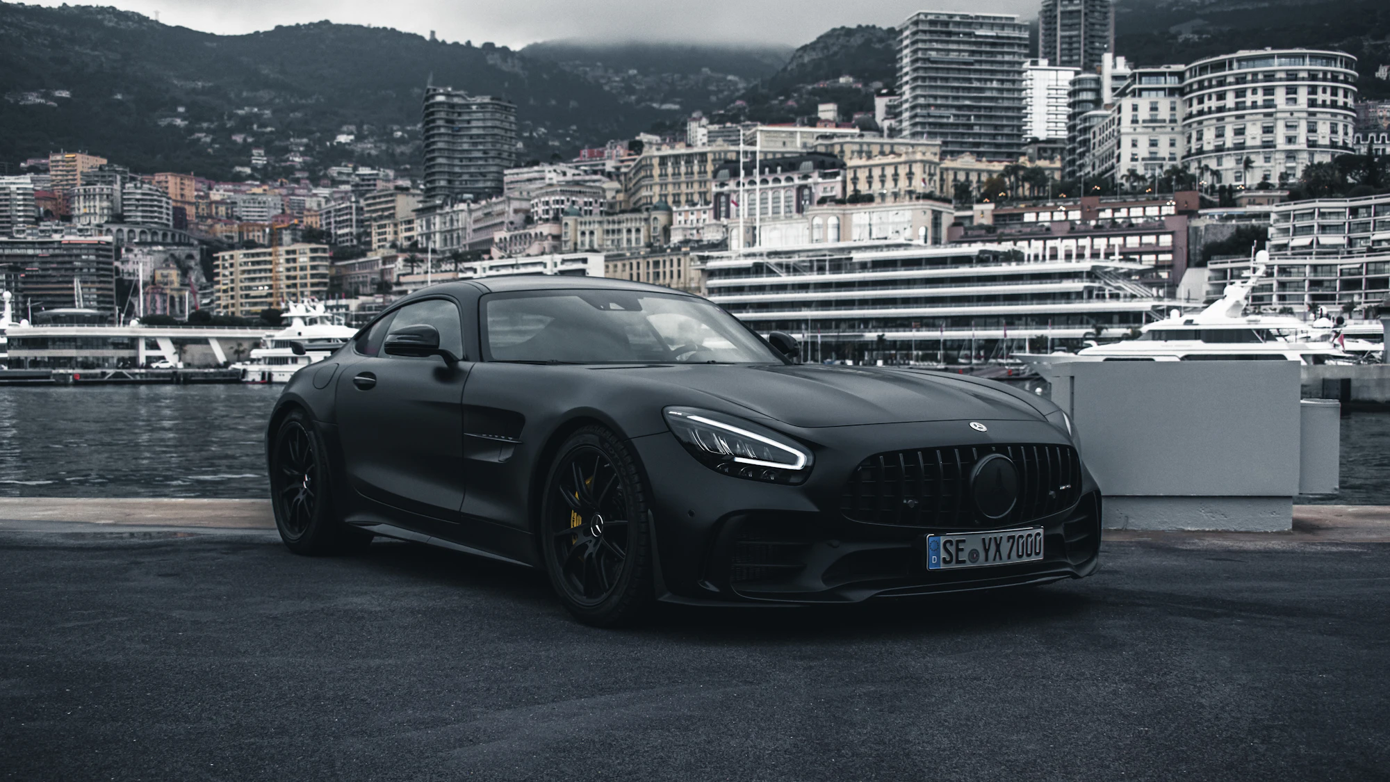 Matte black Mercedes AMG GT parked on a harbour quay