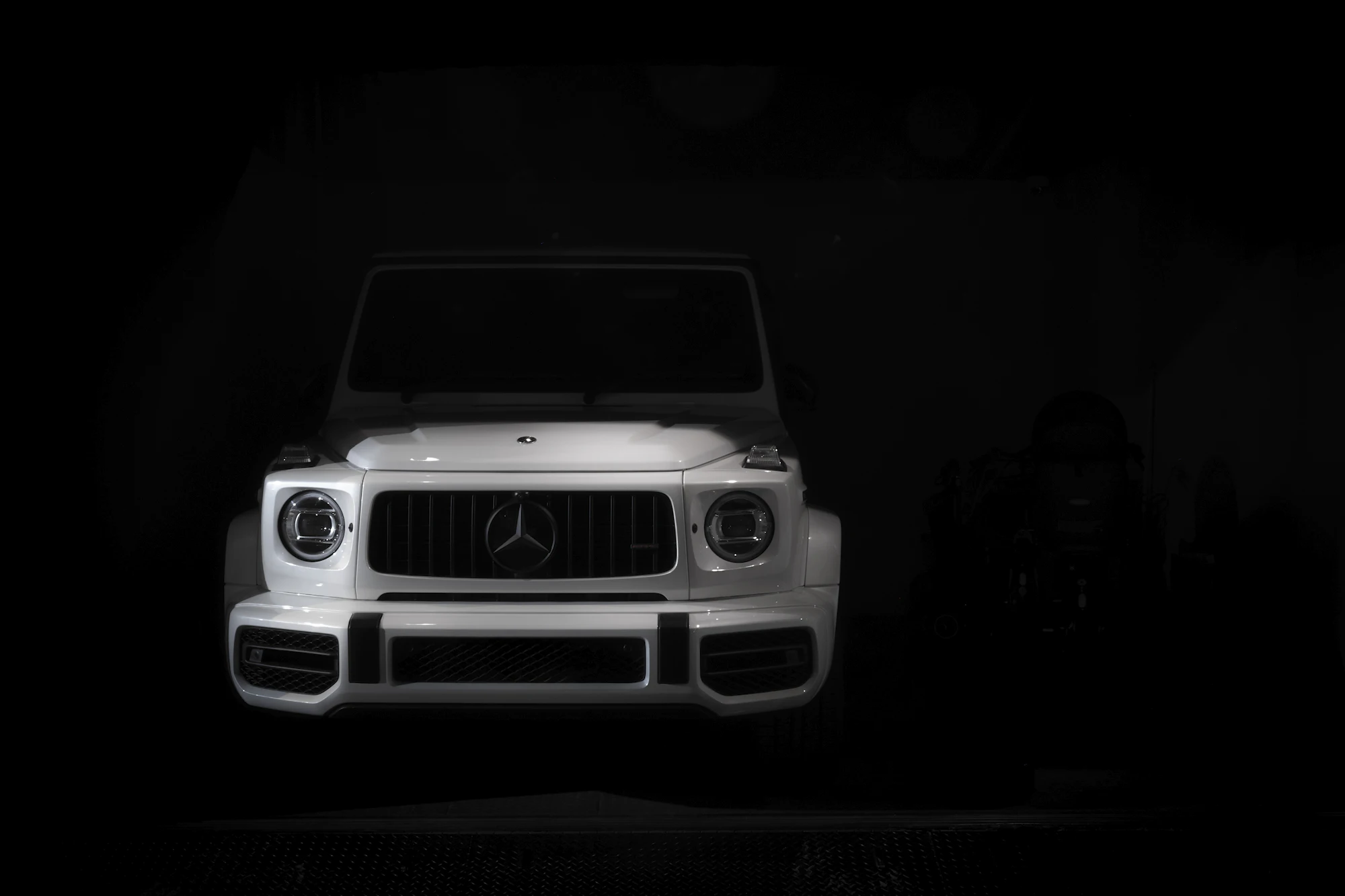 White Mercedes AMG G 63 emerging from the dark